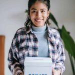 A girl holding a Donate box.