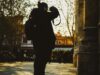 Silhouette of a photographer capturing urban scenes at sunset, evoking creativity and exploration.