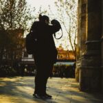 Silhouette of a photographer capturing urban scenes at sunset, evoking creativity and exploration.