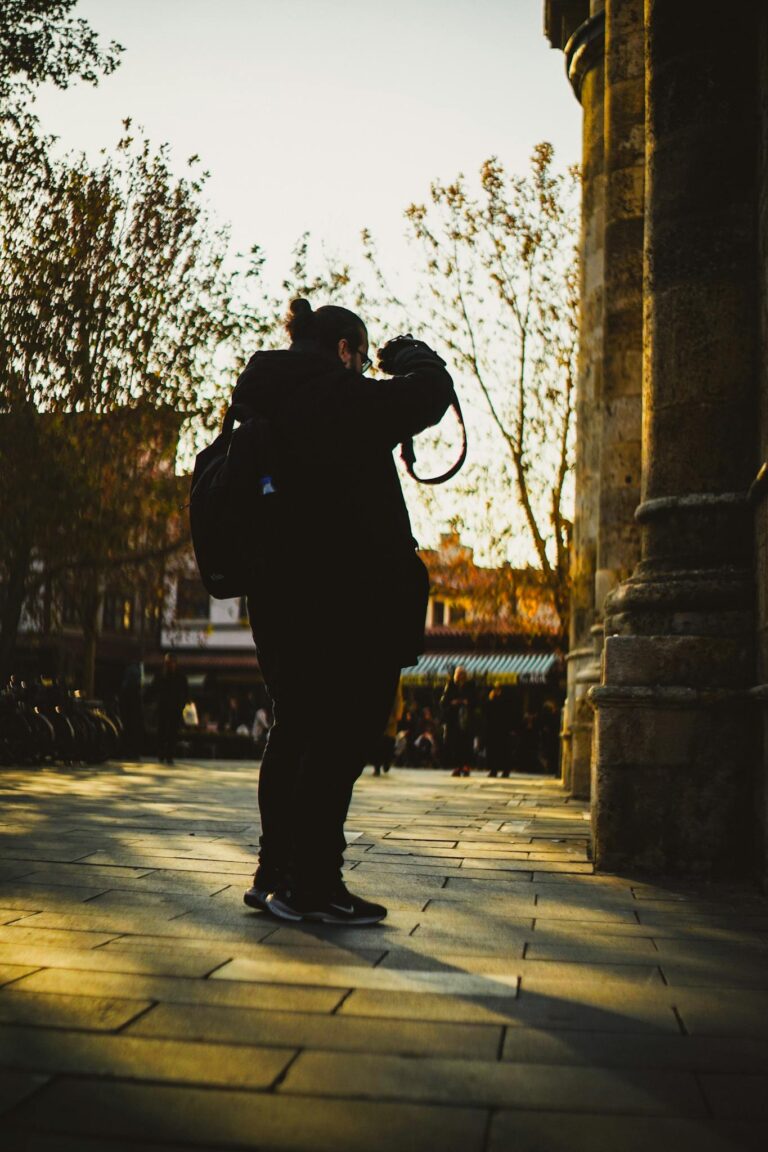 Silhouette of a photographer capturing urban scenes at sunset, evoking creativity and exploration.